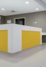 Prestige PUR homogeneous vinyl flooring in pale grey around a yellow reception desk